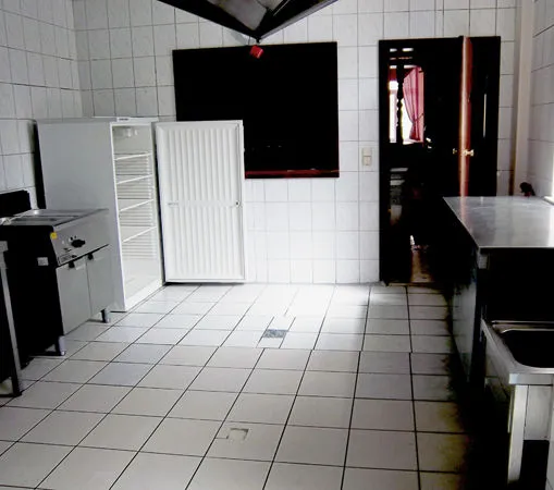 Küche mit Kühlschrank, Arbeitsflächen und gefliestem Boden
